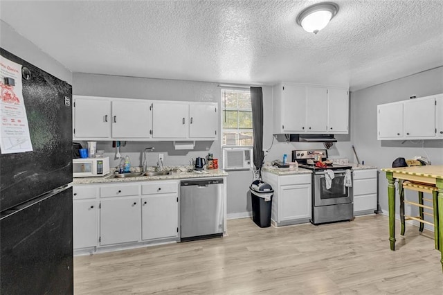 kitchen featuring stainless steel appliances, a sink, a textured ceiling, white cabinetry, and light countertops