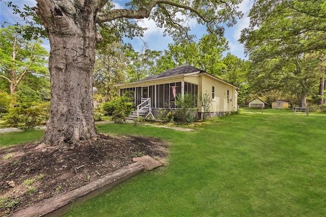 view of side of property with a sunroom and a yard