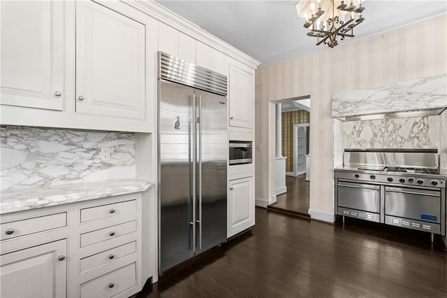 401 Peachtree Battle Ave NW, Atlanta, GA 30305 - kitchen featuring built in appliances, dark wood-type flooring, a chandelier, white cabinets, and crown molding