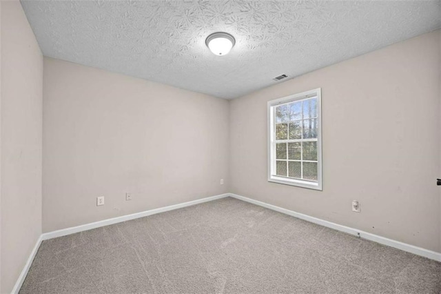 empty room with carpet and a textured ceiling