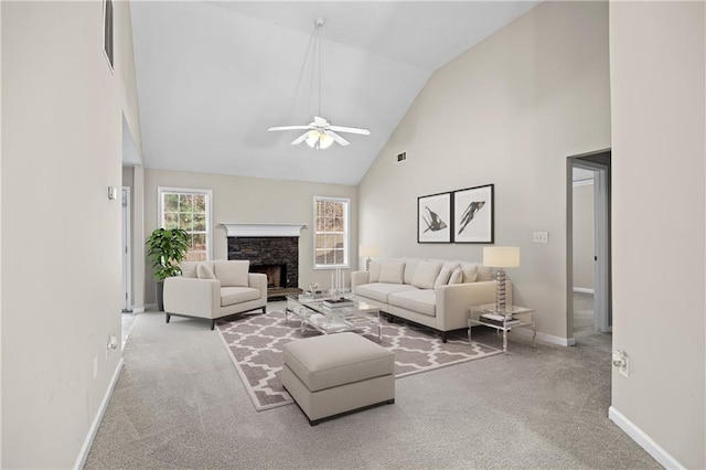 carpeted living room featuring a stone fireplace, high vaulted ceiling, and ceiling fan