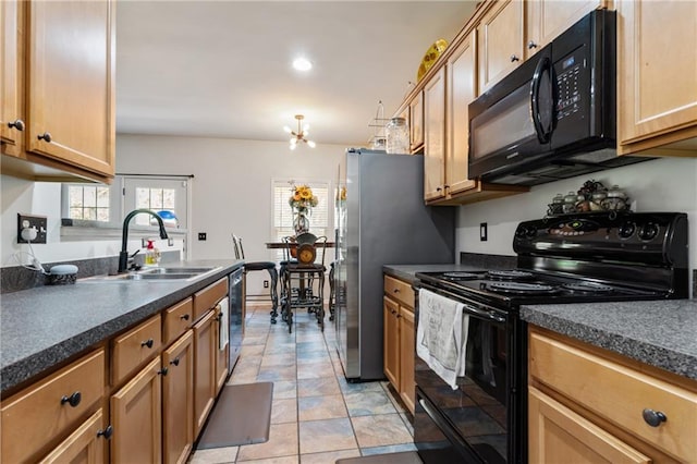 kitchen featuring dark countertops, a wealth of natural light, a sink, and black appliances