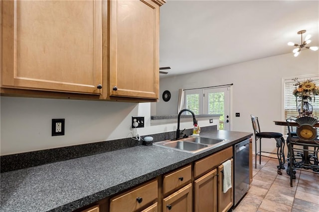 kitchen with dark countertops, stainless steel dishwasher, a sink, a peninsula, and a notable chandelier