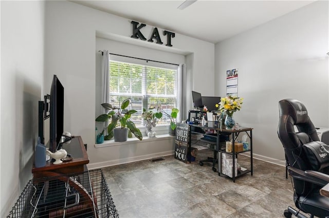 home office featuring baseboards, visible vents, and stone finish floor