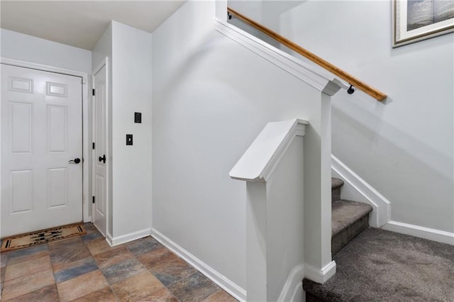 interior space with baseboards, stone finish flooring, and stairway