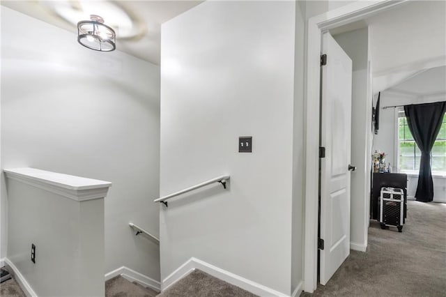 stairway featuring baseboards and carpet