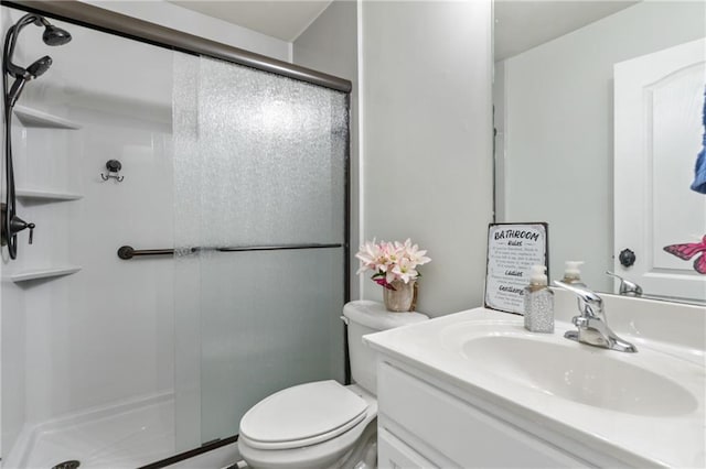 bathroom with vanity, toilet, and a stall shower