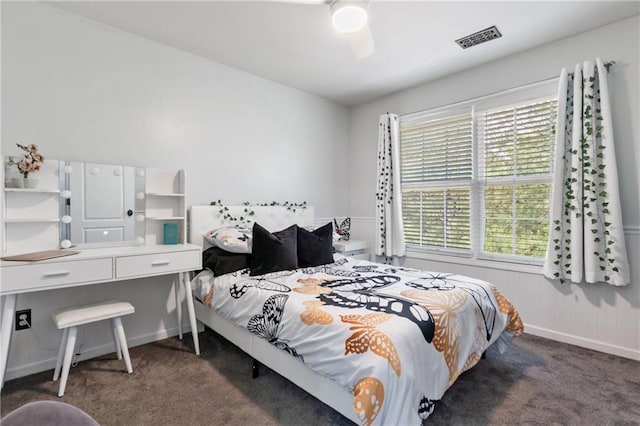 bedroom with baseboards, ceiling fan, visible vents, and dark carpet