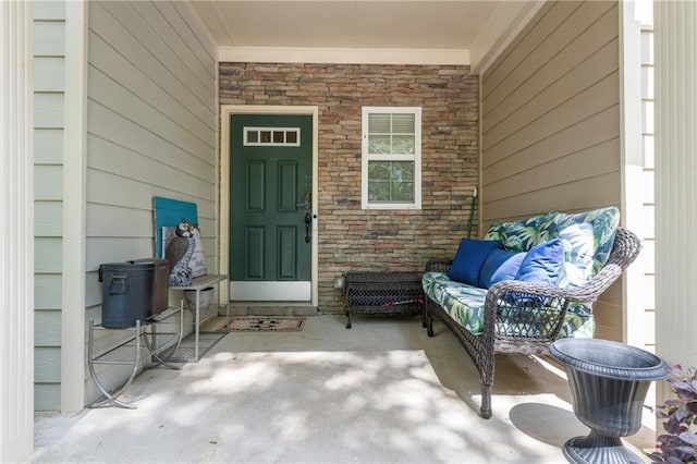 view of exterior entry with outdoor lounge area and stone siding