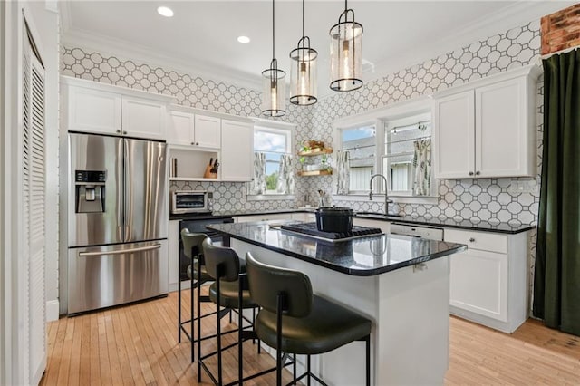 218 S Ave SE, Atlanta, GA 30315 - kitchen with appliances with stainless steel finishes, a sink, white cabinets, a kitchen breakfast bar, and crown molding