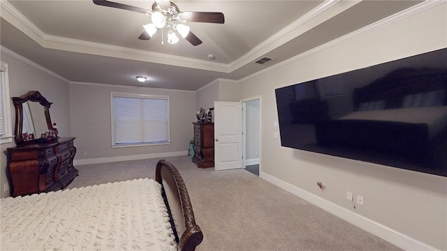 carpeted bedroom with a tray ceiling, ceiling fan, and ornamental molding