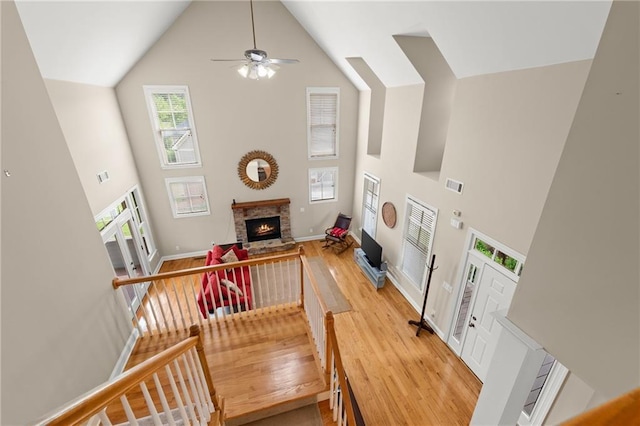 541 Brown Dr, Clermont, GA 30527 - living area with high vaulted ceiling, a ceiling fan, wood finished floors, a brick fireplace, and baseboards