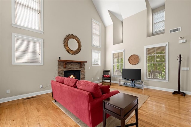 541 Brown Dr, Clermont, GA 30527 - living area with high vaulted ceiling, wood finished floors, a stone fireplace, and baseboards