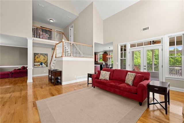541 Brown Dr, Clermont, GA 30527 - living room featuring high vaulted ceiling, wood finished floors, stairs, baseboards, and french doors