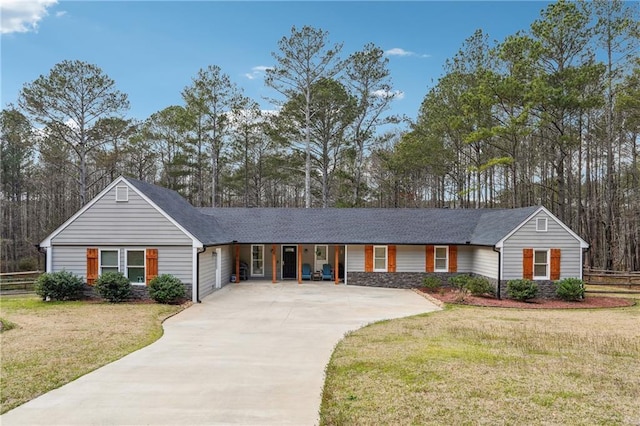 ranch-style house featuring concrete driveway, fence, and a front yard