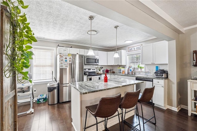 kitchen featuring dark wood-type flooring, white cabinets, stone countertops, and stainless steel appliances