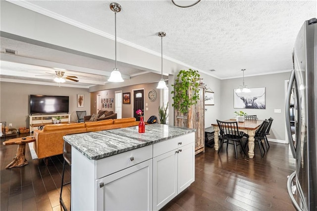 kitchen featuring visible vents, dark wood-type flooring, white cabinetry, freestanding refrigerator, and light stone countertops