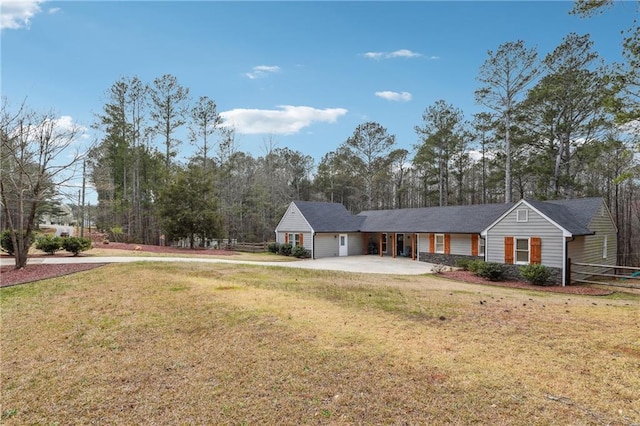 ranch-style house featuring concrete driveway and a front lawn