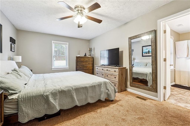 carpeted bedroom featuring a ceiling fan, baseboards, visible vents, and a textured ceiling