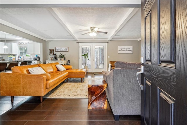 living room with wood tiled floor, beamed ceiling, a textured ceiling, and a ceiling fan