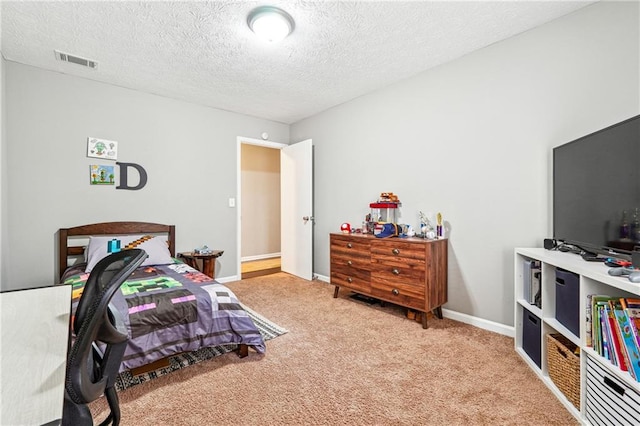 bedroom with visible vents, a textured ceiling, baseboards, and carpet