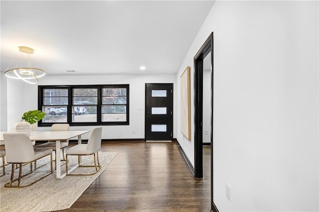 dining room with a notable chandelier and dark hardwood / wood-style floors