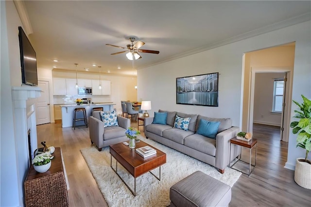 2929 Rambler Dr, Loganville, GA 30052 - living area featuring a ceiling fan, light wood-style floors, crown molding, and recessed lighting