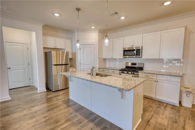 2929 Rambler Dr, Loganville, GA 30052 - kitchen with appliances with stainless steel finishes, a sink, ornamental molding, white cabinets, and tasteful backsplash