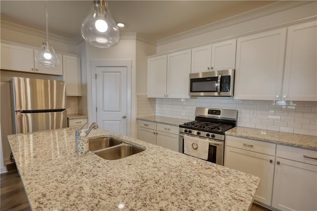2929 Rambler Dr, Loganville, GA 30052 - kitchen featuring stainless steel appliances, a sink, crown molding, a center island with sink, and white cabinets