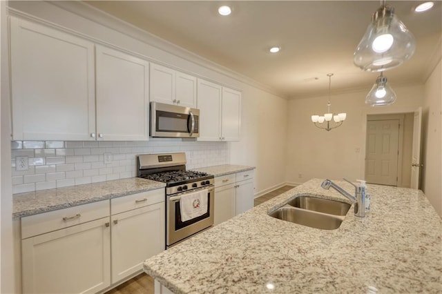 2929 Rambler Dr, Loganville, GA 30052 - kitchen featuring appliances with stainless steel finishes, a sink, light wood-type flooring, backsplash, and white cabinets