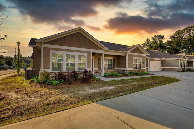 2929 Rambler Dr, Loganville, GA 30052 - craftsman house with an attached garage, covered porch, driveway, cooling unit, and brick siding