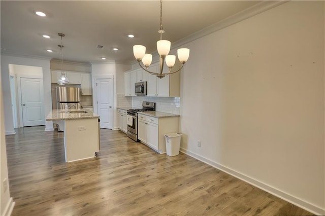 2929 Rambler Dr, Loganville, GA 30052 - kitchen featuring stainless steel appliances, crown molding, decorative backsplash, white cabinetry, and a chandelier