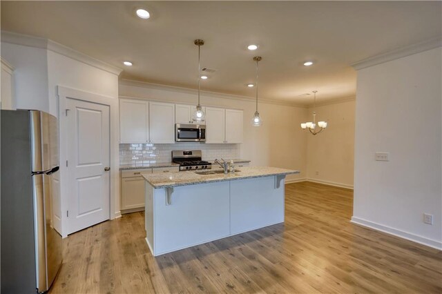 2929 Rambler Dr, Loganville, GA 30052 - kitchen with appliances with stainless steel finishes, a sink, crown molding, white cabinets, and tasteful backsplash