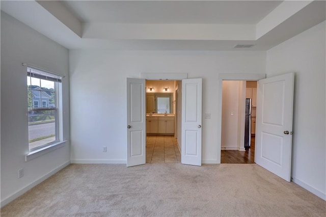 2929 Rambler Dr, Loganville, GA 30052 - unfurnished bedroom with carpet floors, a tray ceiling, and baseboards