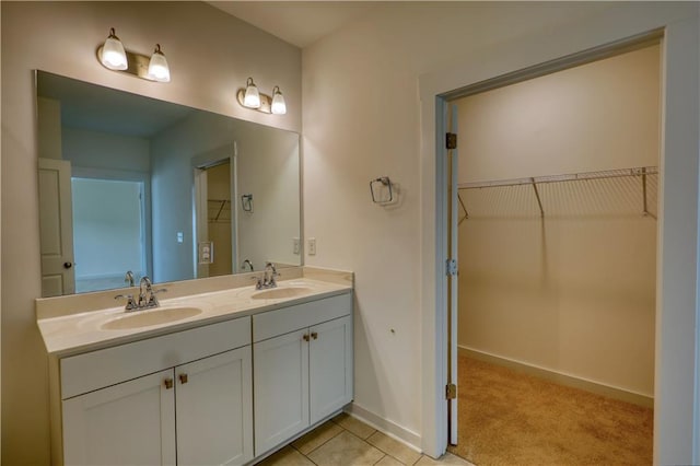 2929 Rambler Dr, Loganville, GA 30052 - bathroom with double vanity, baseboards, and a walk in closet
