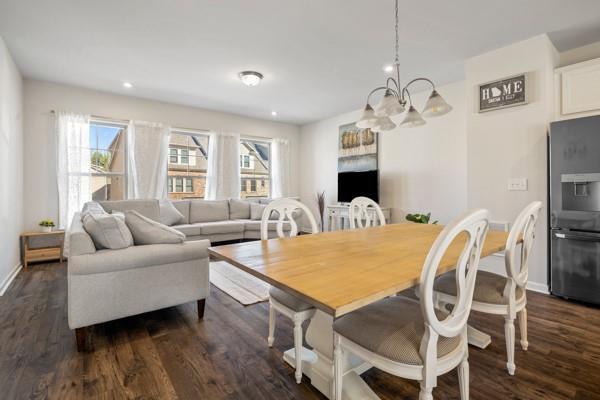 dining room with baseboards, dark wood-style floors, a notable chandelier, and a healthy amount of sunlight