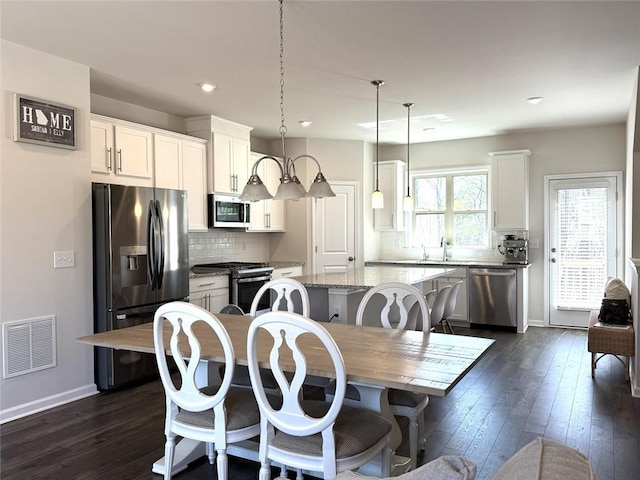 dining area featuring visible vents, baseboards, recessed lighting, and dark wood finished floors
