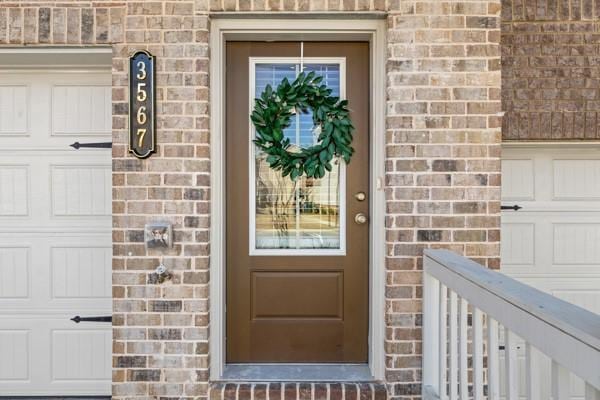 view of exterior entry with brick siding