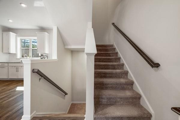 staircase featuring baseboards, recessed lighting, and wood finished floors