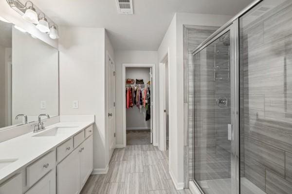 bathroom featuring a sink, visible vents, and a stall shower