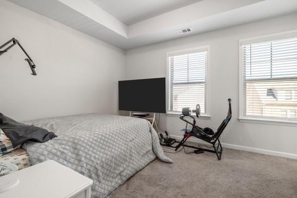 bedroom featuring visible vents, baseboards, multiple windows, and carpet flooring