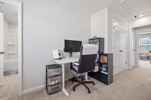 carpeted office with baseboards and attic access