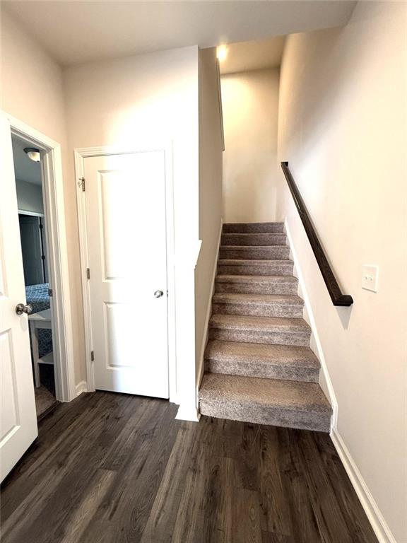 stairs featuring wood finished floors and baseboards