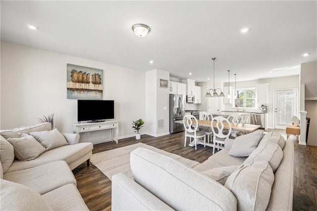 living room with visible vents, baseboards, recessed lighting, and dark wood finished floors