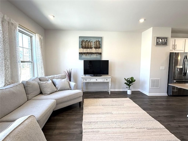living area with dark wood-type flooring, baseboards, visible vents, and recessed lighting