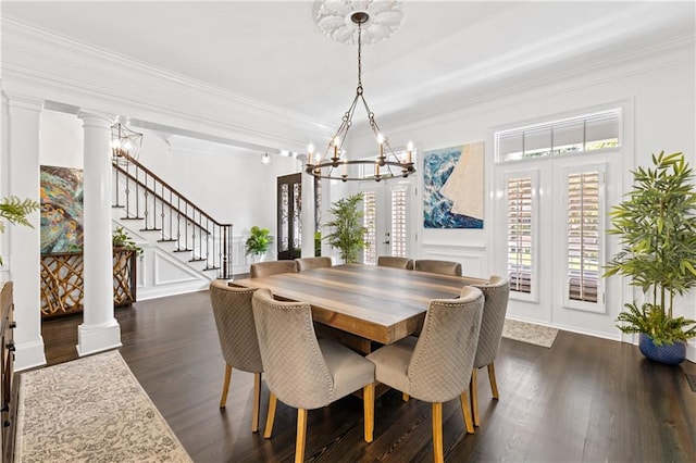 dining room featuring a notable chandelier, ornate columns, crown molding, and dark wood-type flooring