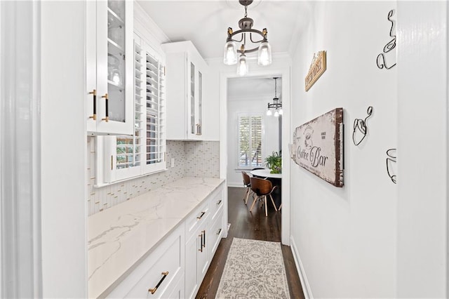 interior space featuring a notable chandelier, dark hardwood / wood-style floors, and crown molding