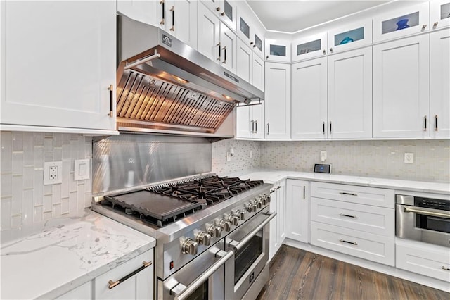 kitchen with light stone counters, white cabinetry, stainless steel appliances, and tasteful backsplash