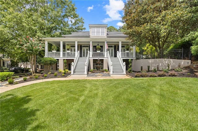 view of front facade with a porch, stairway, and a front yard
