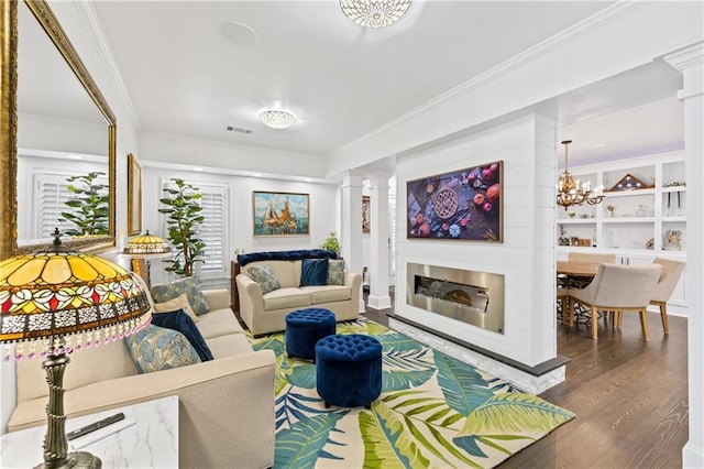 living room with dark wood-type flooring, built in features, decorative columns, crown molding, and a chandelier